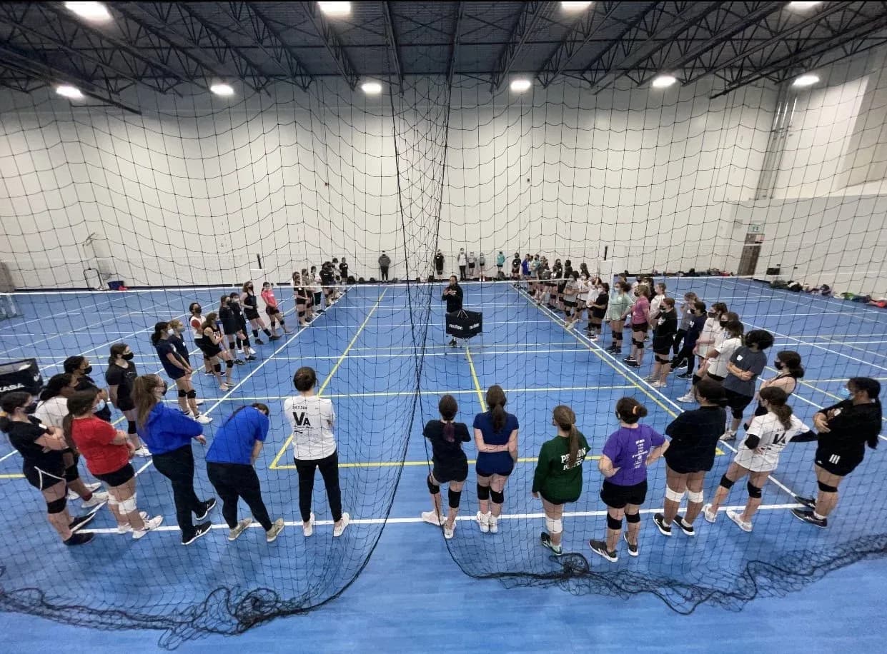 Volleyball coach talking with parents at a youth practice in Winnipeg